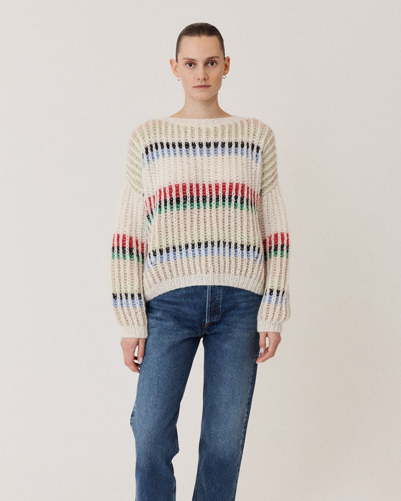 Model wearing hand-knitted structured sweater in creme made of alpaca wool
