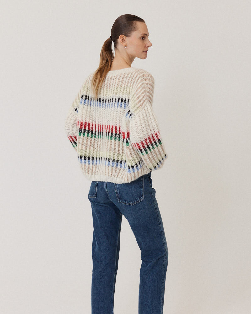 Model wearing hand-knitted structured sweater in creme made of alpaca wool