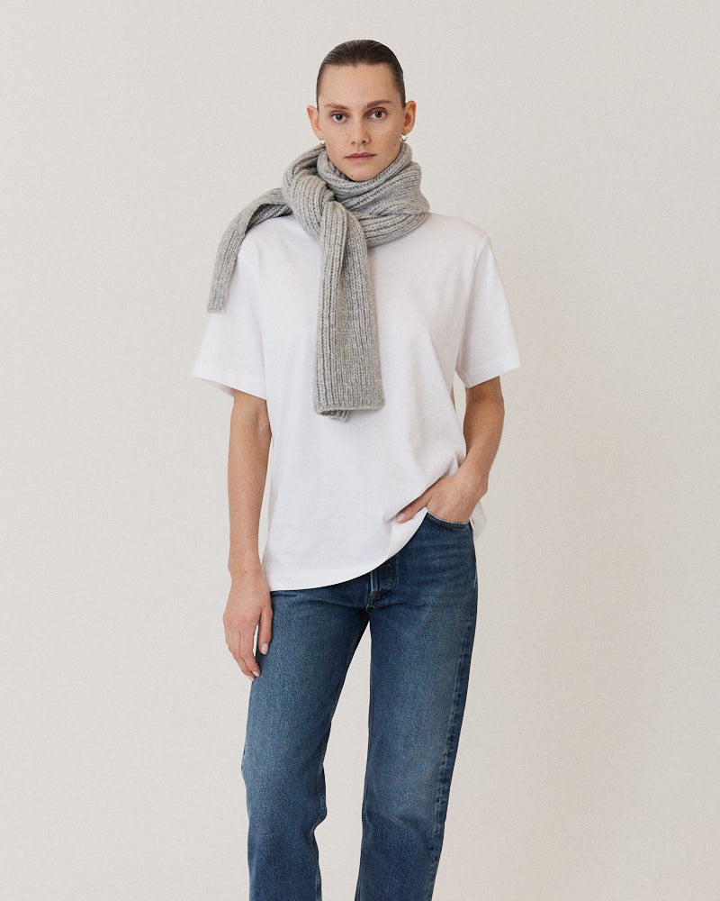 Model wearing light grey knitted scarf