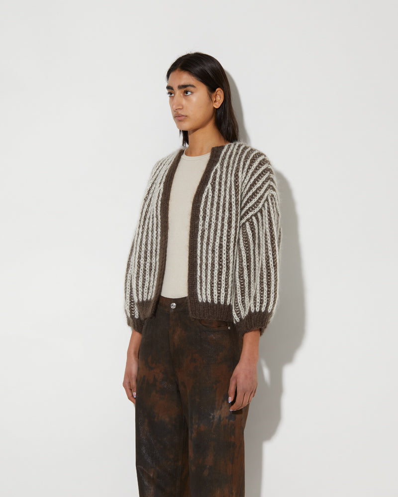 Model wearing a mohair brioche bomber cardigan with two-tone vertical stripes and cropped silhouette