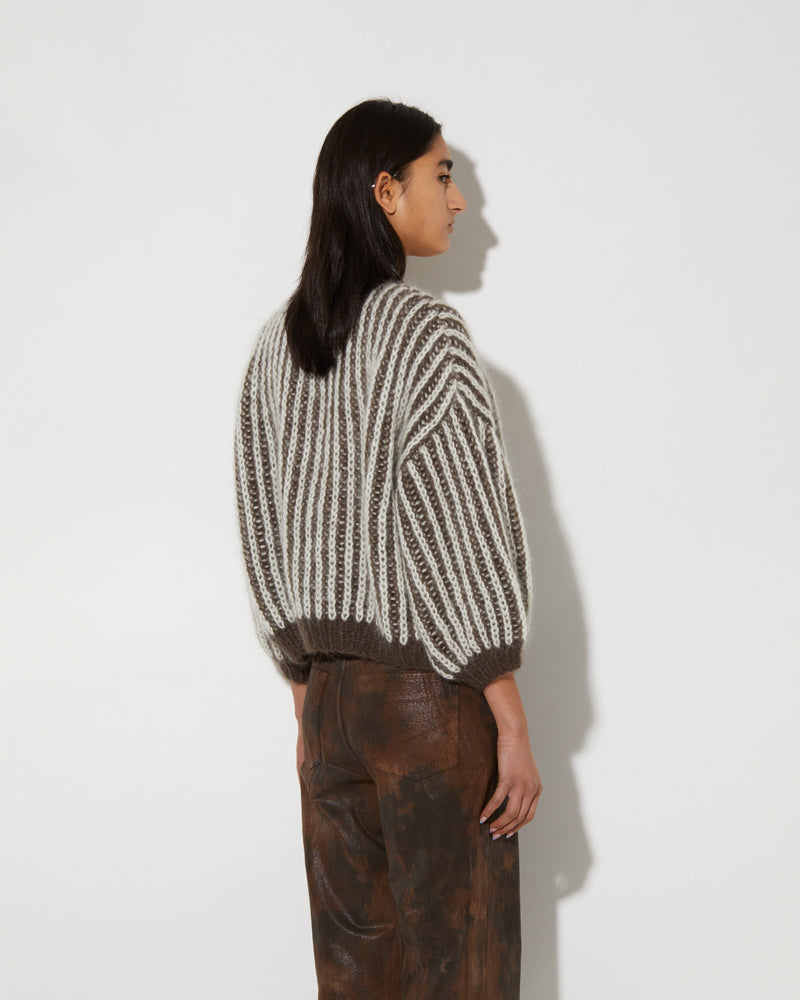 Model wearing a mohair brioche bomber cardigan with two-tone vertical stripes and cropped silhouette