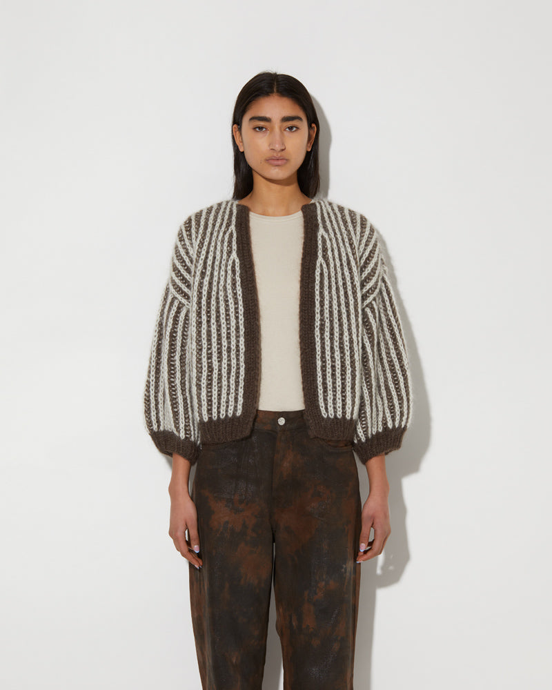 Model wearing a mohair brioche bomber cardigan with two-tone vertical stripes and cropped silhouette