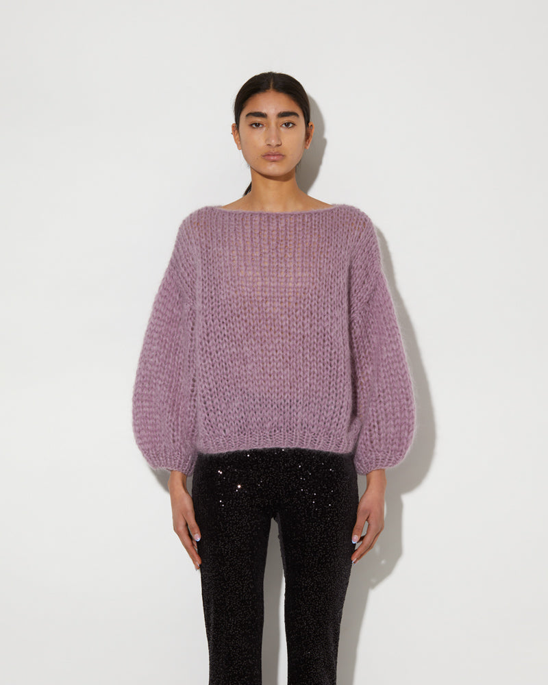 Model wearing an oversized mohair sweater with textured knit and voluminous sleeves in a soft purple tone