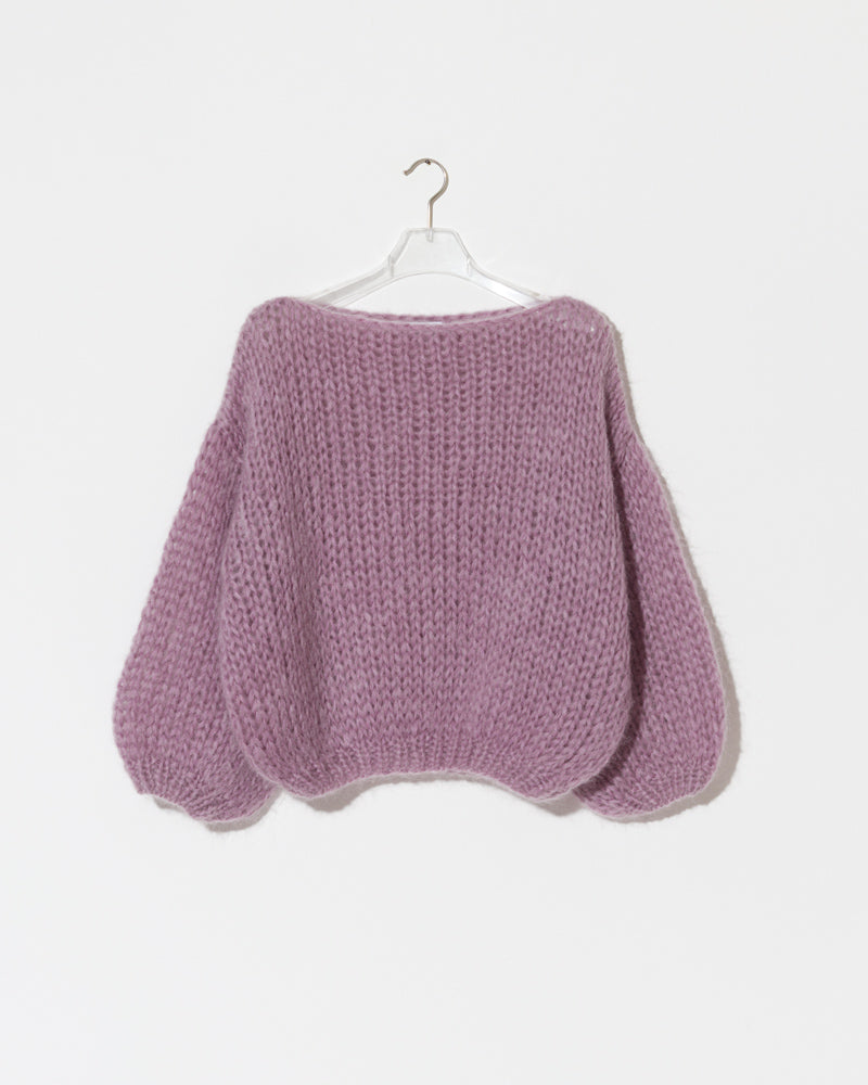 Model wearing an oversized mohair sweater with textured knit and voluminous sleeves in a soft purple tone
