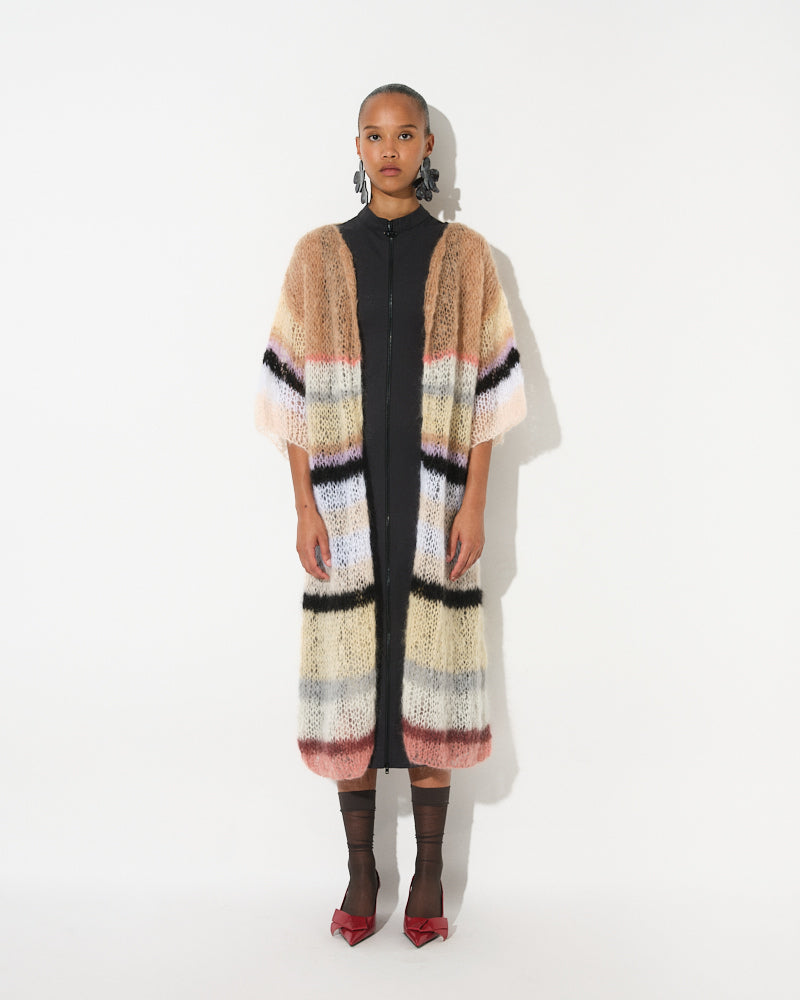 Model wearing a long mohair striped coat with multicolour bands and open front silhouette