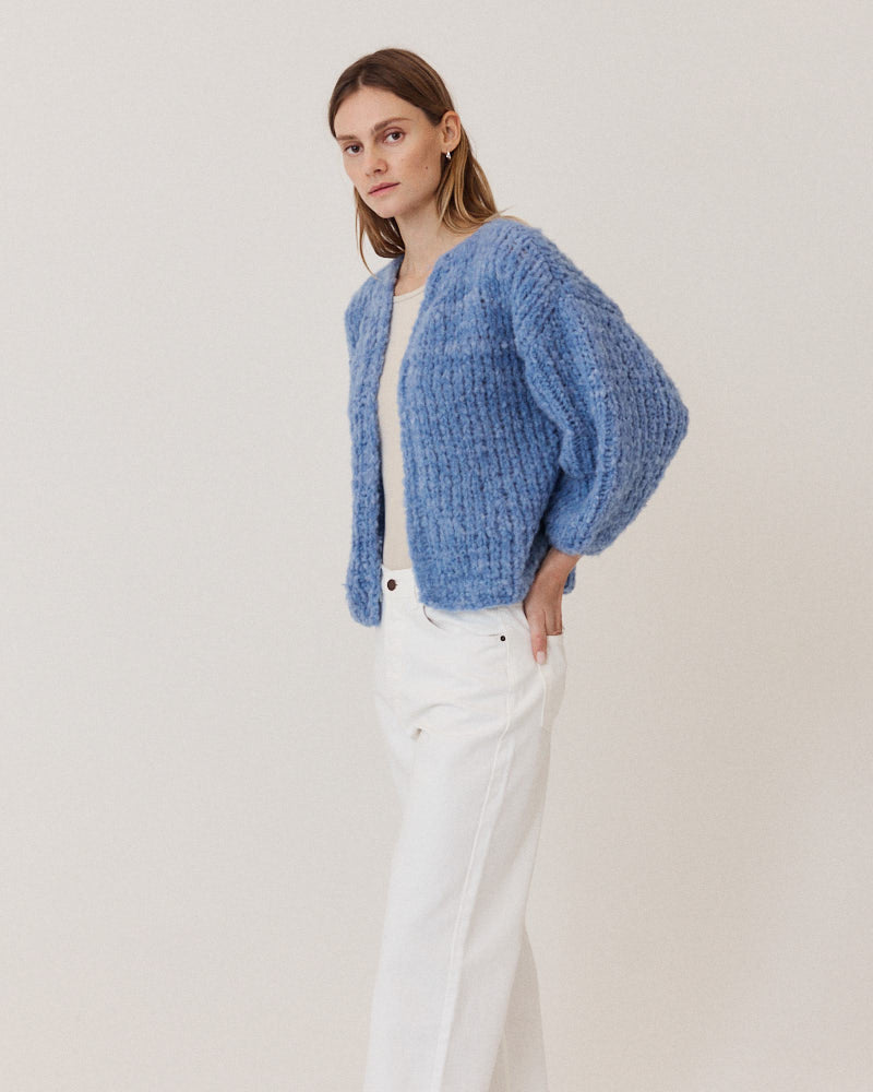 Model wearing structured hand-knitted alpaca cardigan in light blue