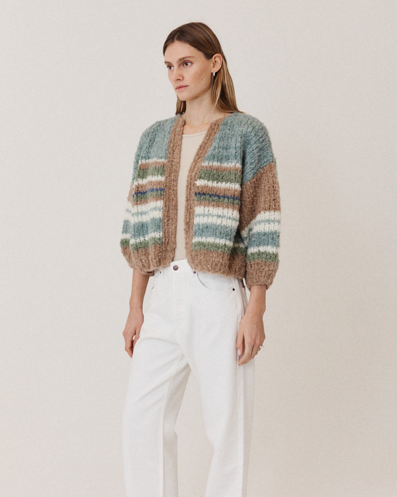 Model wearing hand-knitted alpaca cardigan with stripes in green tones