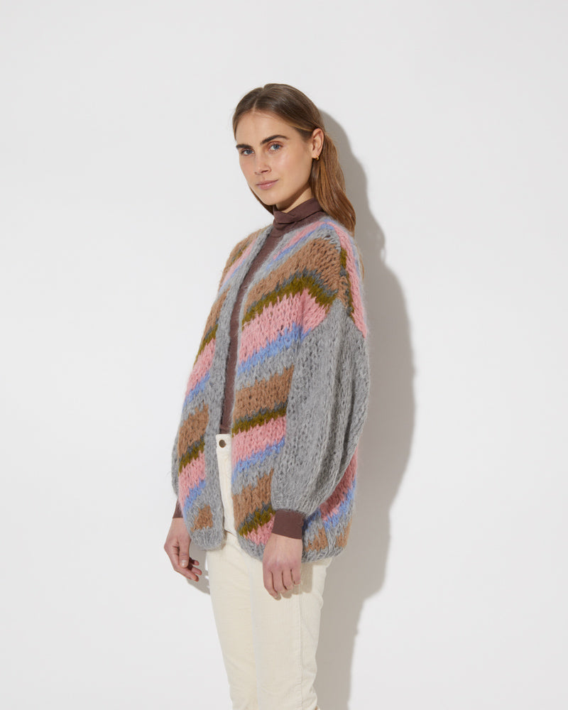 View from the side of model wearing the new in Alpaca Big Cardigan with diagonal stripes in the color 'Strawberry Sky'