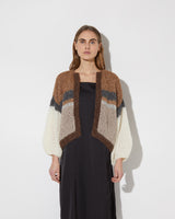 Frontal view of model wearing the new in Alpaca Mix Bomber Cardigan in the color 'Camel Stripes' with a dress 
