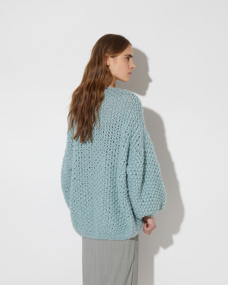 View from the back of model wearing the new in Alpaca Pearl Pattern Cardigan - long in the color 'Steel Green 2187'