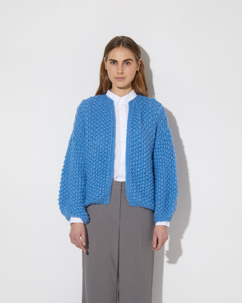 Frontal view of model wearing the new in Alpaca Pearl Pattern Bomber Cardigan in the color 'China Blue 3709'