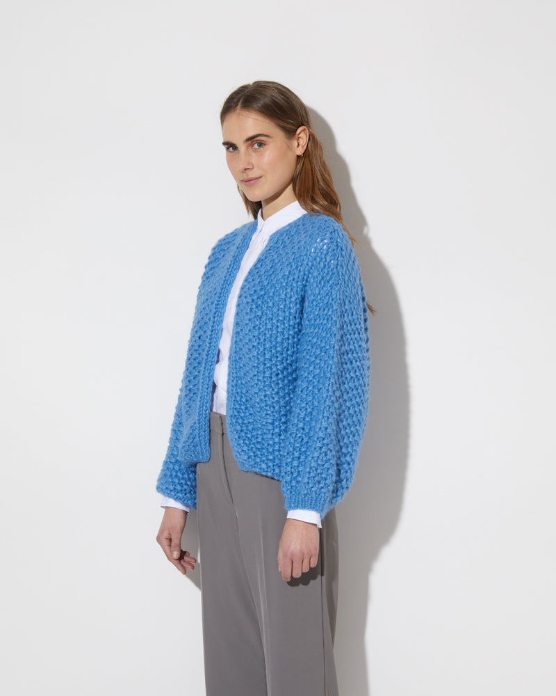 View from the side of model wearing the new in Alpaca Pearl Pattern Bomber Cardigan in the color 'China Blue 3709'