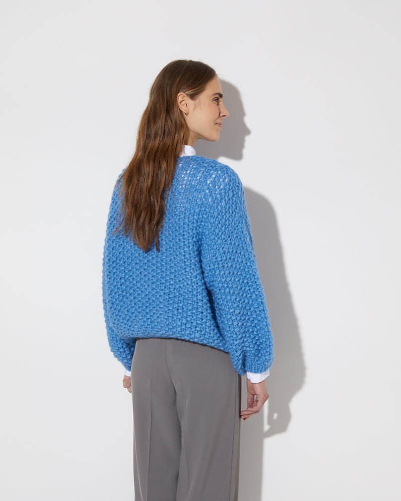 Frontal view of model wearing the new in Alpaca Pearl Pattern Bomber Cardigan in the color 'China Blue 3709'