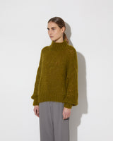 View from the side of model wearing the new in Alpaca Turtleneck Pullover in the color 'Khaki L509'