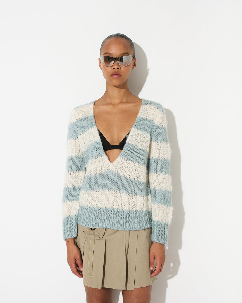 Model wearing a soft alpaca striped V-neck pullover with relaxed fit and horizontal stripes in light tones