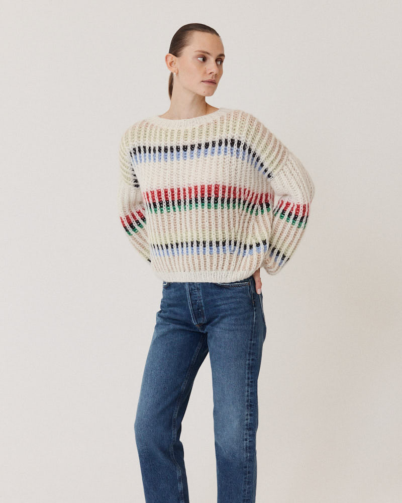 Model wearing hand-knitted structured sweater in creme made of alpaca wool