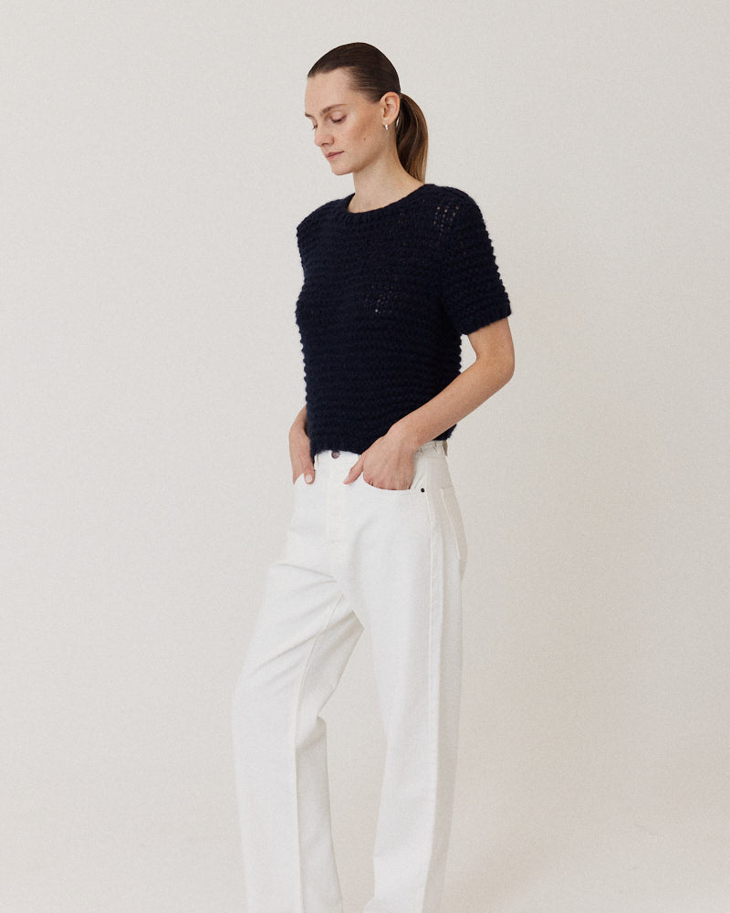 Model wearing hand knitted cashmere sweater with short sleeves in navy