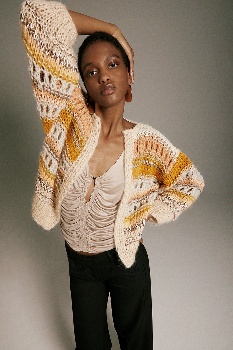 Frontal view of Model wearing the Texture Galore Bomber Cardigan in sand.
