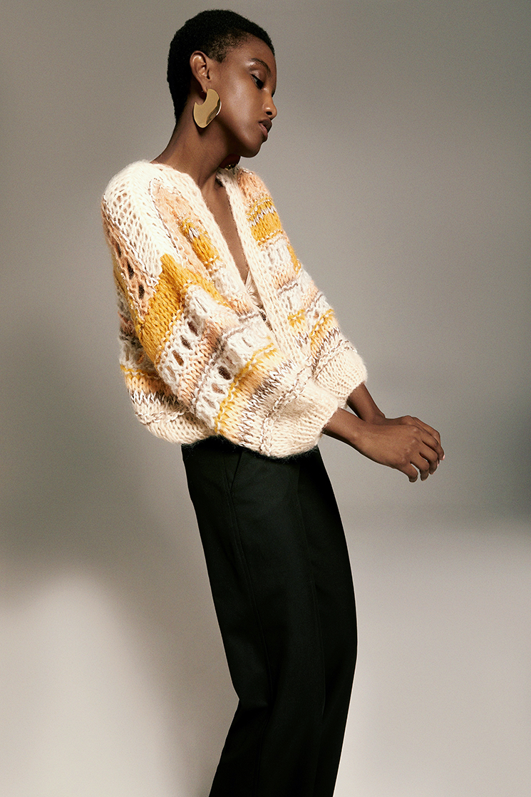 Side view of Model wearing the Texture Galore Bomber Cardigan in sand.