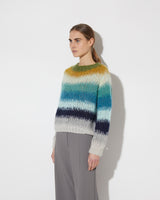 View from the side of model wearing the Gradient Fade Pullover in the color 'Soft Fall'