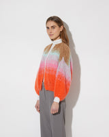 View from the side of model wearing the Gradient Fade Mohair Bomber Cardigan in the color 'Cool Pastel'