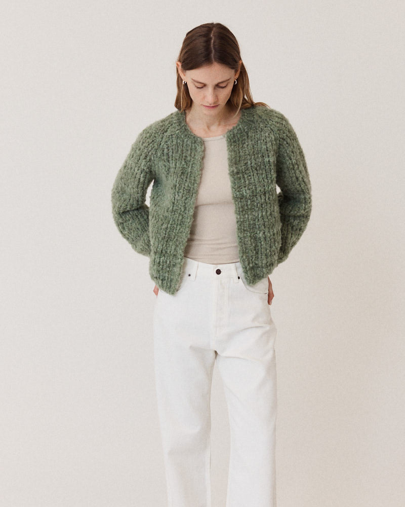 Model wearing structured hand-knitted alpaca cardigan in olive green