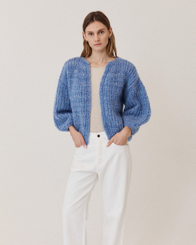 Model wearing structured hand-knitted alpaca cardigan in light blue
