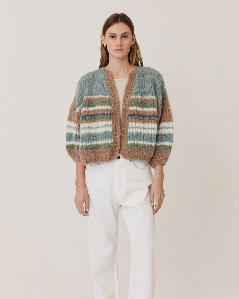 Model wearing hand-knitted alpaca cardigan with stripes in green tones