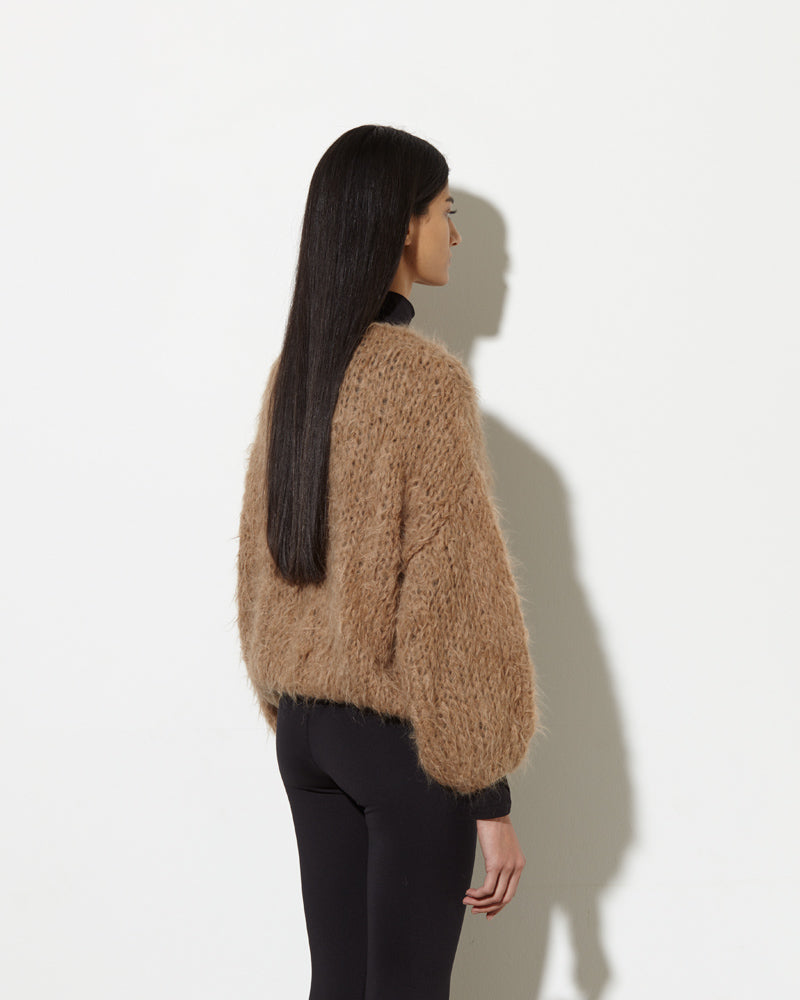 Model from back the wearing Alpaca cardigan in beige brown.