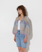 model wearing the spring boucle bomber cardigan in haze. Shot from the side