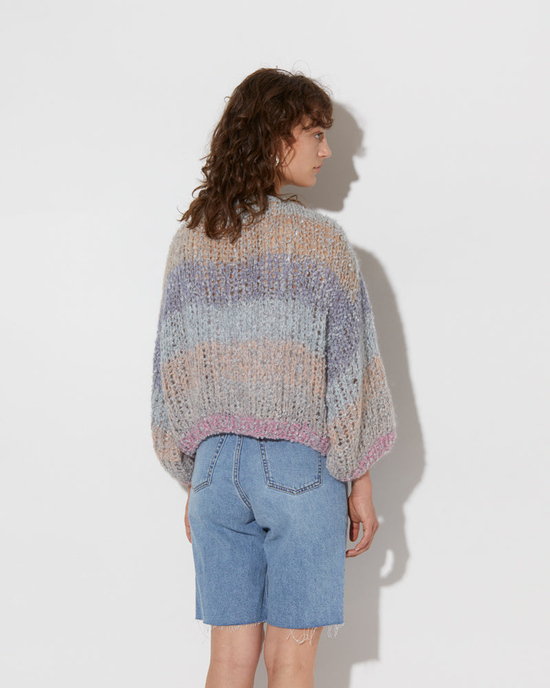 model wearing the spring boucle bomber cardigan in haze. Shot from the back