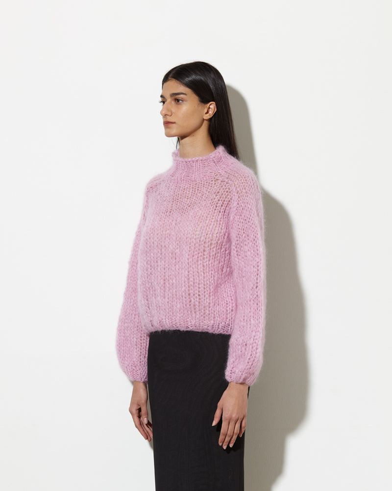 model from the side wearing Mohair turtleneck in rose. hand-knitted with love.