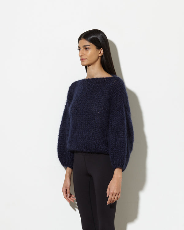 model from the side wearing mohair sweater in navy. soft and cozy feel.
