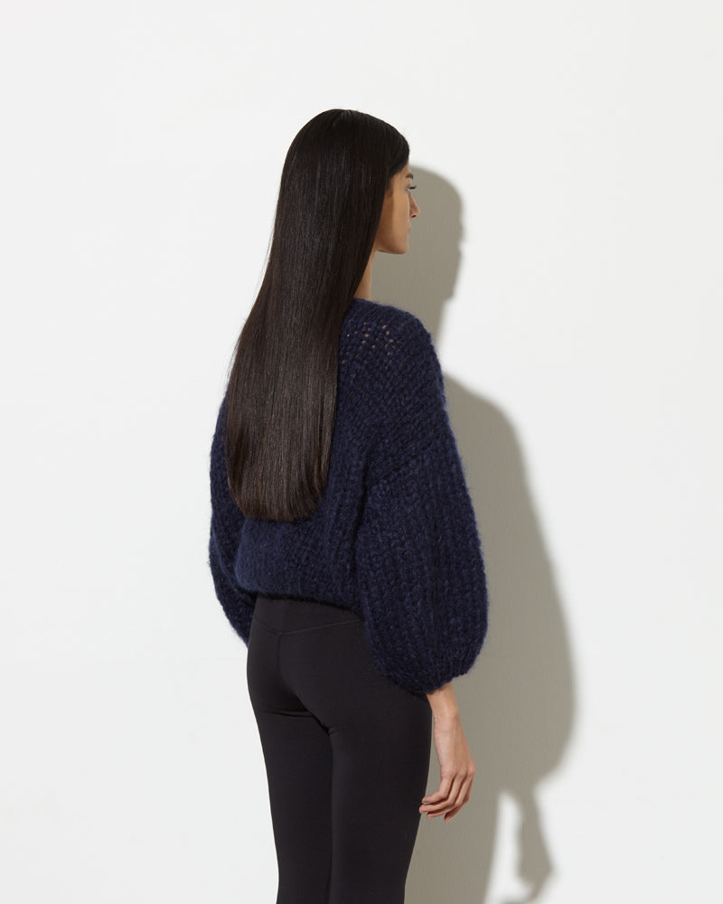 model from the back wearing mohair sweater in navy. soft and cozy feel.