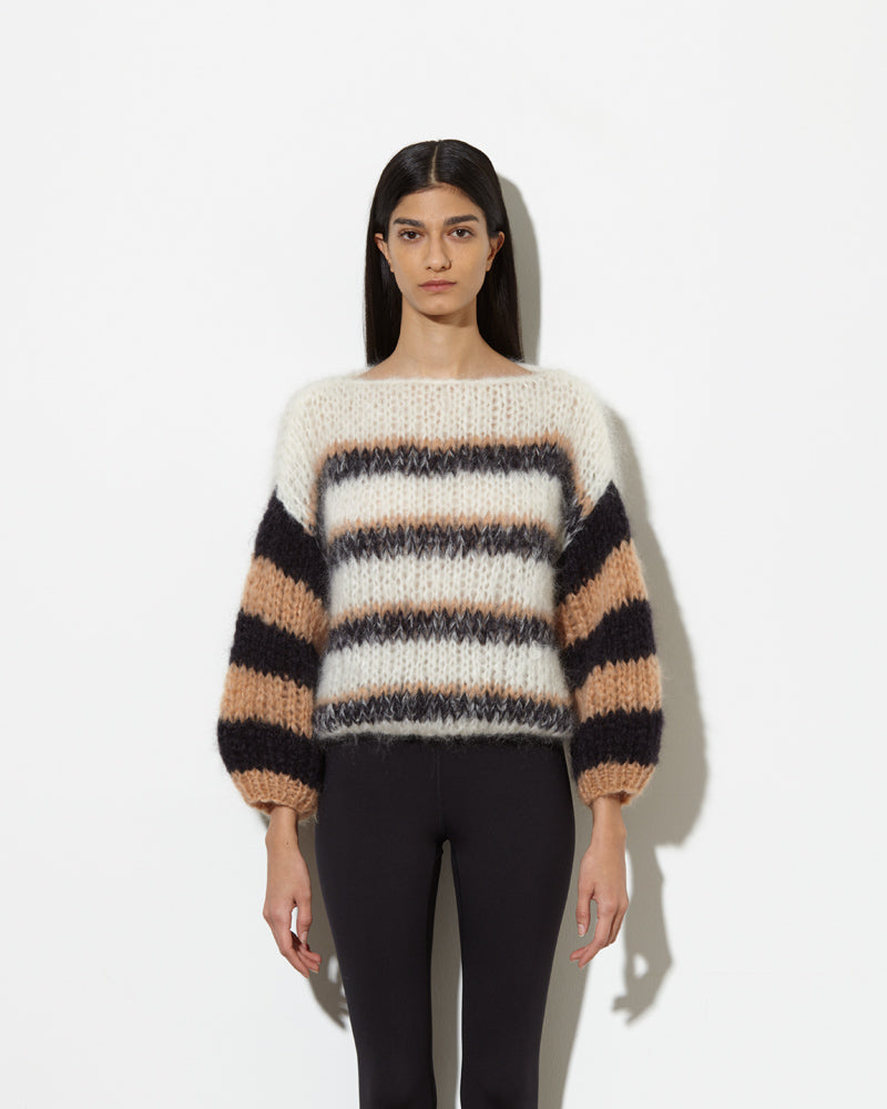 Model wearing Sweater with stripes in creme black.