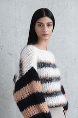 Model posing wearing Sweater with stripes in creme black.