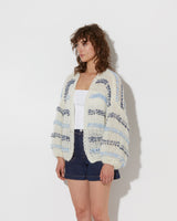 model wearing the wavy spring mohair bomber cardigan in creme-blue. Shot from the side